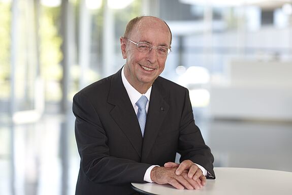 Porträt von Berthold Leibinger im Jahre 2010, an einem Tisch stehend