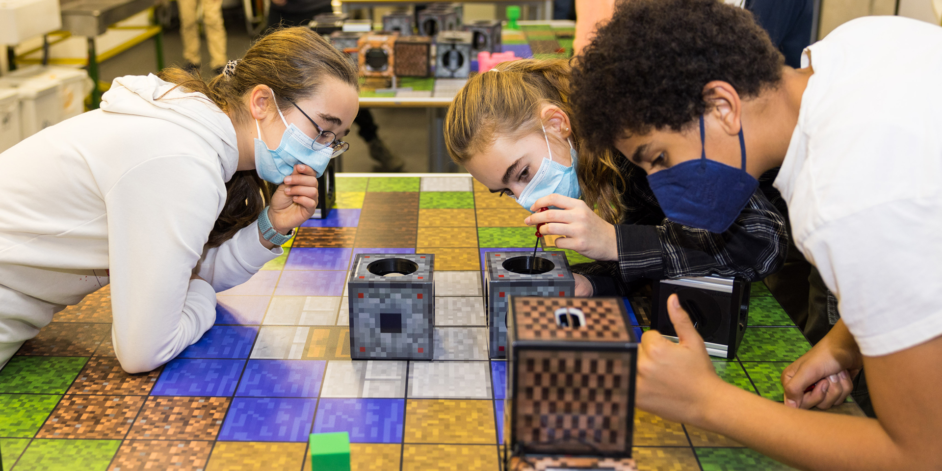 Jugendliche spielen mit Minecraft-Würfeln am Tisch