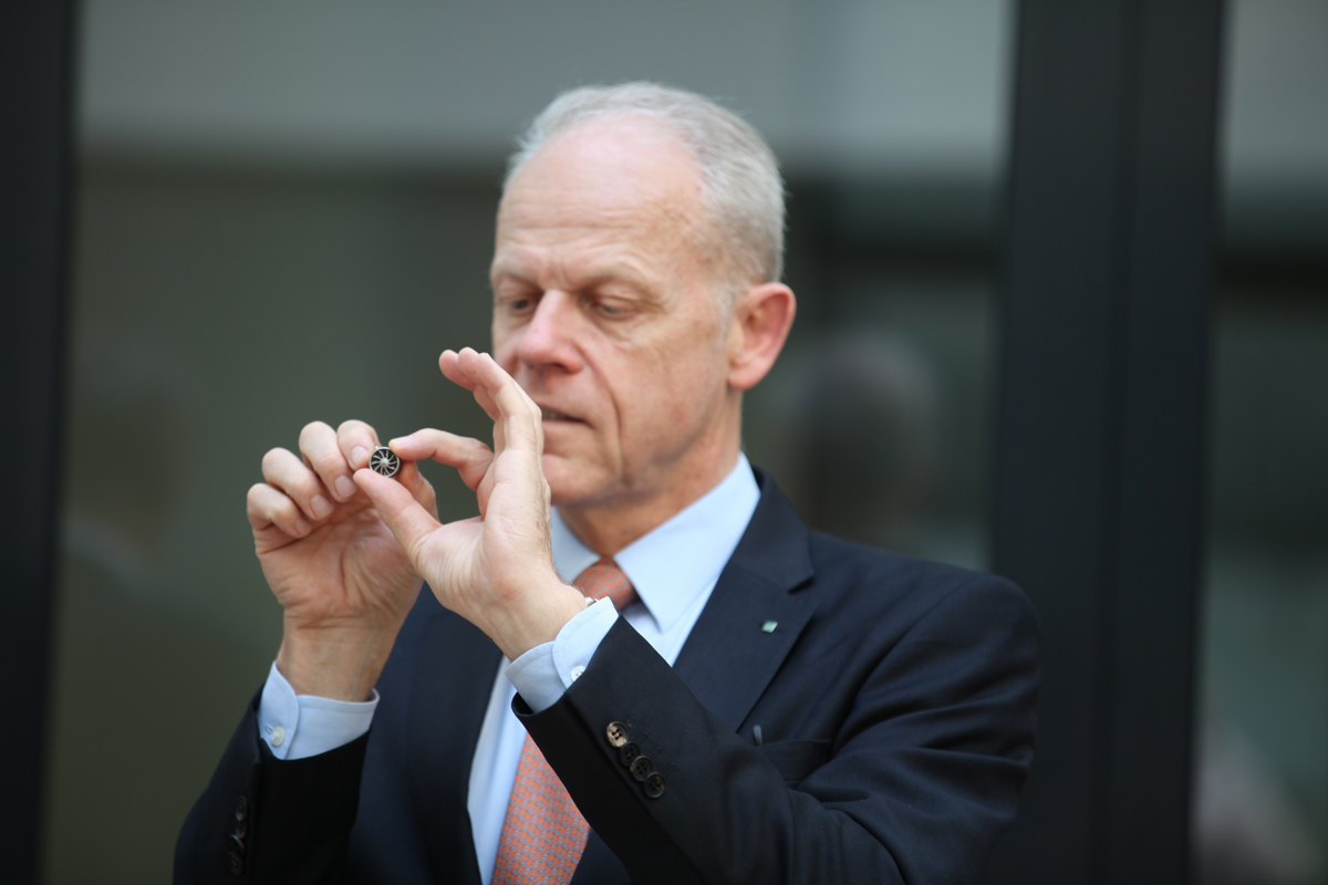 Mann zeigt kleines Bauteil